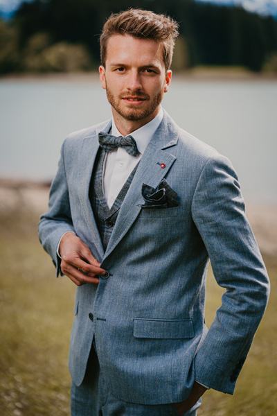 Der Bräutigam im blauen Leinen Hochzeitsanzug auf der Bergsee-Hochzeit